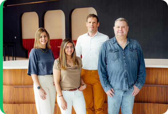 Équipe de quatre experts Kenneth Vansina, Melissa Vansina, Eric Piette et Lynn Guillaume posant ensemble dans un bureau moderne, représentant la marque Comparateur-Energie.be.